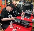 Frank Miller og Greg Capullo der signerer en legetøjs-batmobil ve Midtown Comics.