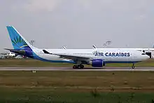 Kig fra siden på et to-motors fly på en landingsbane.