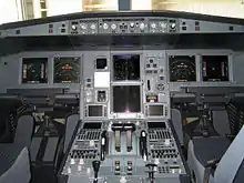 Cockpit på en A330. Alle instrumenter og skærme er tændte. To sæder fylder begge sider af cockpittet adskilt af en centerkonsol.