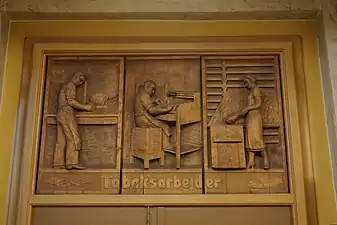 Træskærerarbejde over dør: 'Tobaksarbejder'