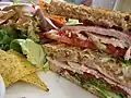 En club sandwich i to lag mellem tre stykker brød
