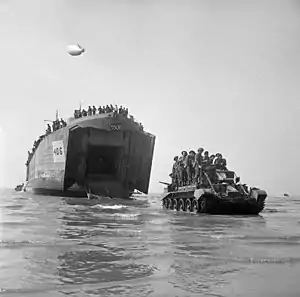 Soldater og en Cromwell kampvogn er netop rykket ud fra et landgangsfartøj.