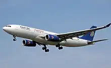 Et to-motorers passagerfly med landingshjulene foldet ned er på vej til at lande