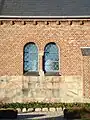 Dobbeltvindue i kirkens skib. Sokkelen i granitsten fra den gamle Krogsbæk Kirke. Søjlens kapitæler er udført i cement.