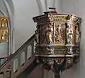 Prædikestolen er udskåret i barokstil fra 1660.