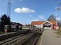 Stationsbygningen ligger for enden af sporene.
