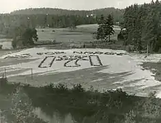 173 nordmænd i den norske flygtningelejr på Öreryd i Jönköpings län i Sverige hyller Kong Haakon hans 70-års fødsesldag 3. august 1942. Foto: Riksarkivet