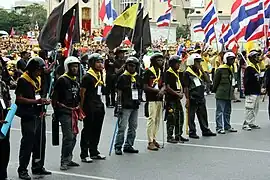 En række bevæbnede Gultrøje-demonstranter ved Democracy Monument (Demokratimonumentet) i Bangkok.