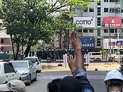 27. feruar, folk viser trefinger-symbol til politiet i Yangon.