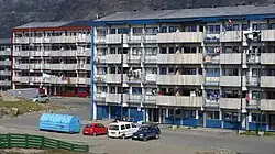 Forskellige typer af bebyggelse i Sisimiut, et præfabrikeret enfamilieshus (venstre) og lejlighedsblokke fra 1960'erne (højre).