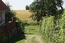 Landsbyen skråner ned mod Lille Vejleå mod syd. På den anden side af åen ligger markerne til herregården Benzondal.