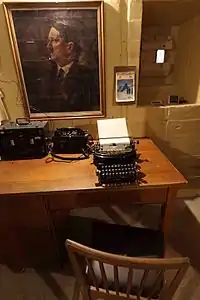 Kontorbord med skrivemaskine og portræt