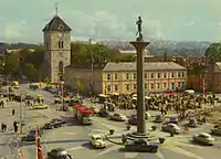 Torvet med monumentet i 1960'erne. Solur-mosaikken blev anlagt 1930. Langs Kongens gate ses Hornemansgården med Vor Frue Kirke bag. Postkort: Trondheim byarkiv