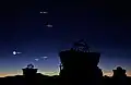 Planetkonjunktion på morgenhimlen 1. maj 2011 omkring en time før solopgang set fra Cerro Paranal i Chile. På den klare himmel ses de fire planeter Merkur, Venus, Mars og Jupiter, Jorden ikke medregnet. De har fået følgeskab af Månen, som viser dels en tiltagende seglfase og dels et kraftigt jordskin. Vinkelafstanden mellem Mars og Jupiter er under en halv grad. I silhouet ses tre af hjælpeteleskoperne til ESOs Very Large Telescope. I baggrunden ses bl. a. bjergtoppen Cerro Armazonas, hvor man i disse år er ved et bygge verdens største teleskop, ESOs Extremely Large Telescope.