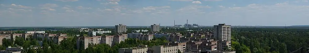 Panorama billede af Pripjat i 2011. Det nedlagte Tjernobyl-atomkraftværk kan ses i baggrunden.
