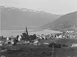 Vossevangen (Vossavangen) omkring 1890 med Voss kirke (Vangskyrkja) fra 1277. Vangsvatnet i baggrunden.Foto:&nbsp;Axel Lindahl (1841–1906)